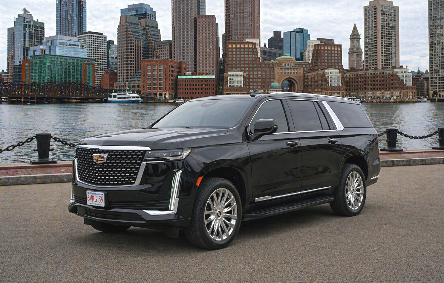 Black Cadillac SUV parked in urban area, city skyline in background.