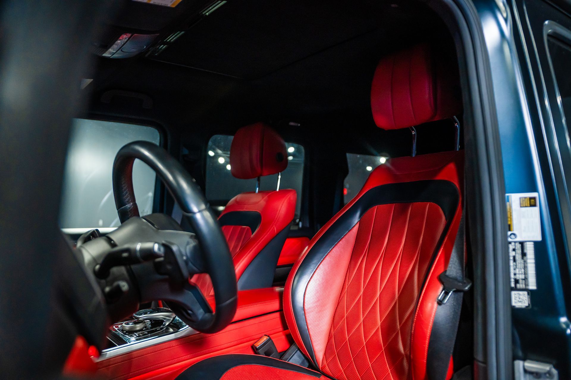 Black and red car interior with sporty bucket seats and steering wheel visible