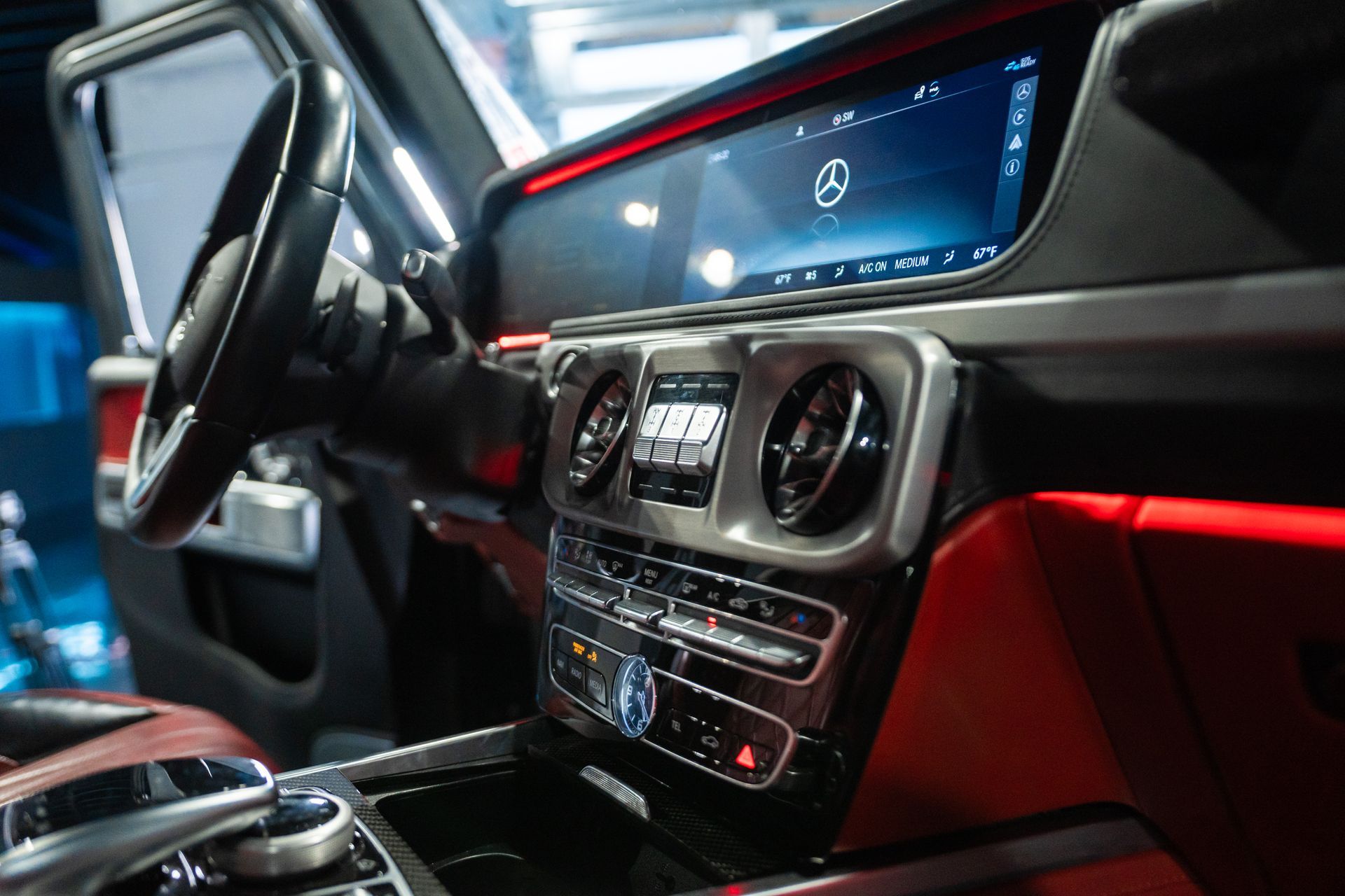 Luxury car interior dashboard with red ambient lighting and a digital display