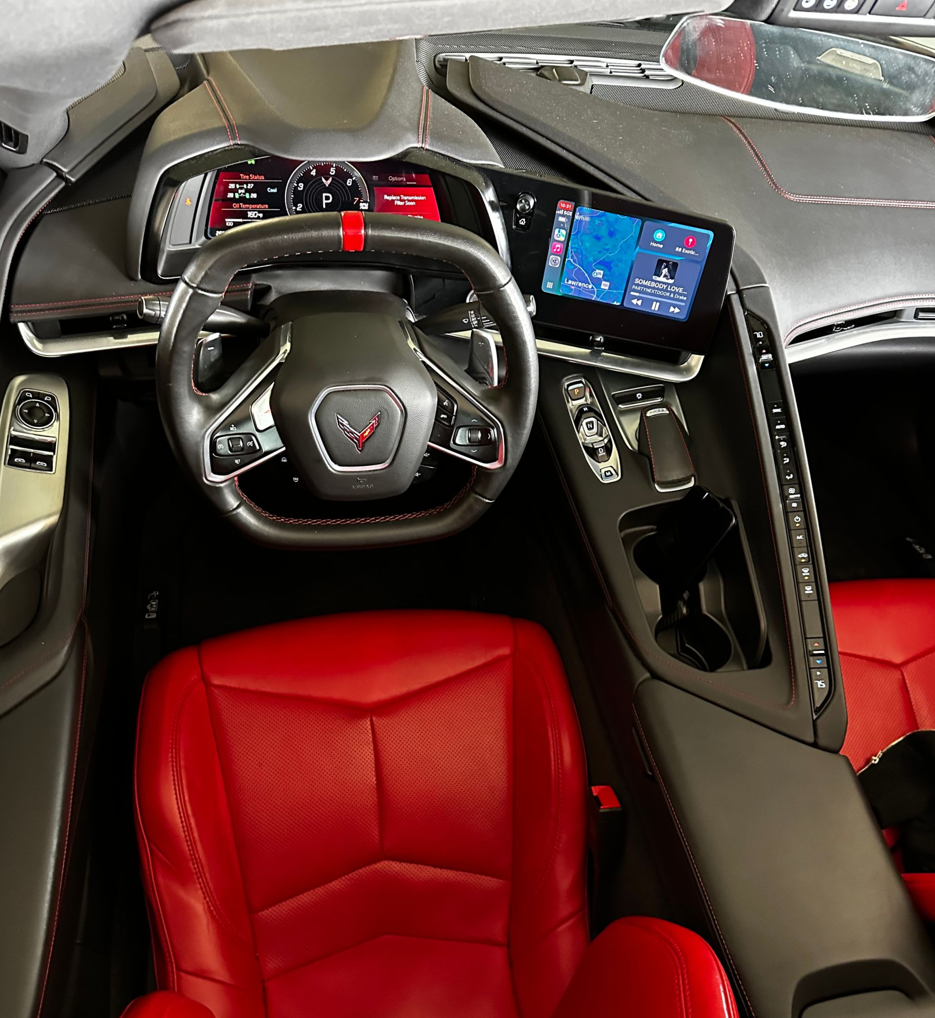 Red leather sports car interior with black dashboard, steering wheel, and center display.