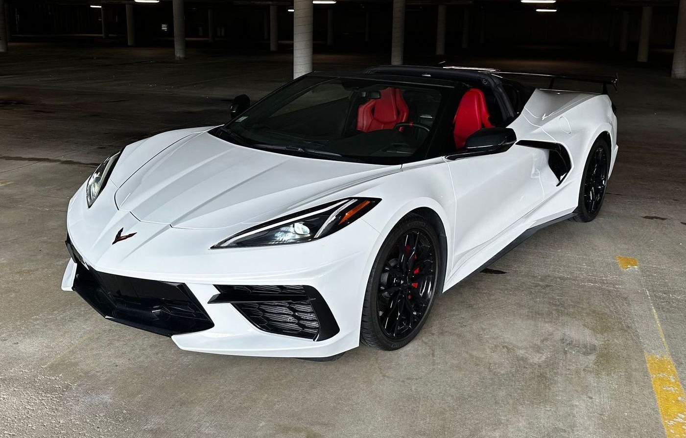 White sports car with red interior parked in a garage