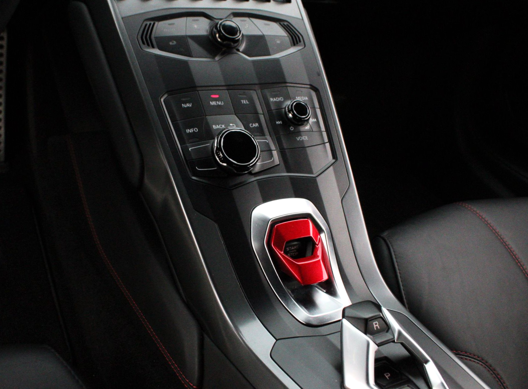 Car center console with climate controls and a red drive mode selector