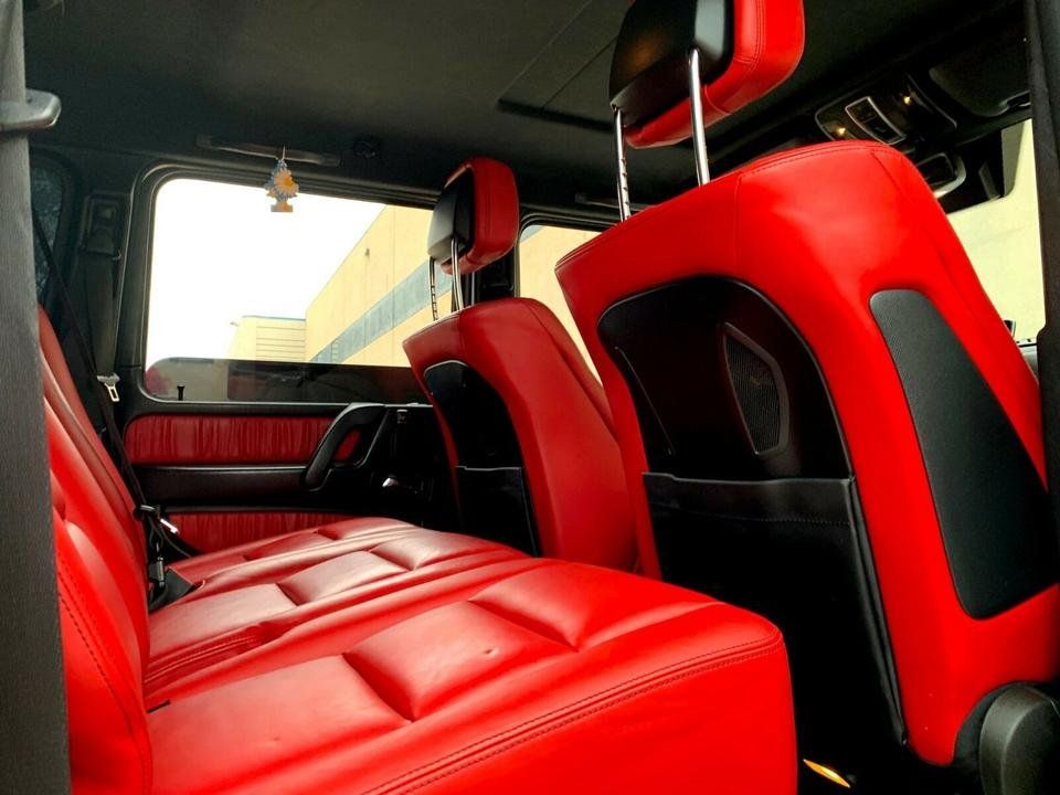 Red and black car interior with bucket seats and a rear bench seat
