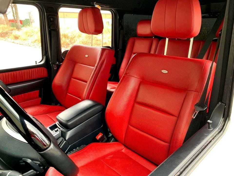 Red leather car interior with front seats, steering wheel, and center console