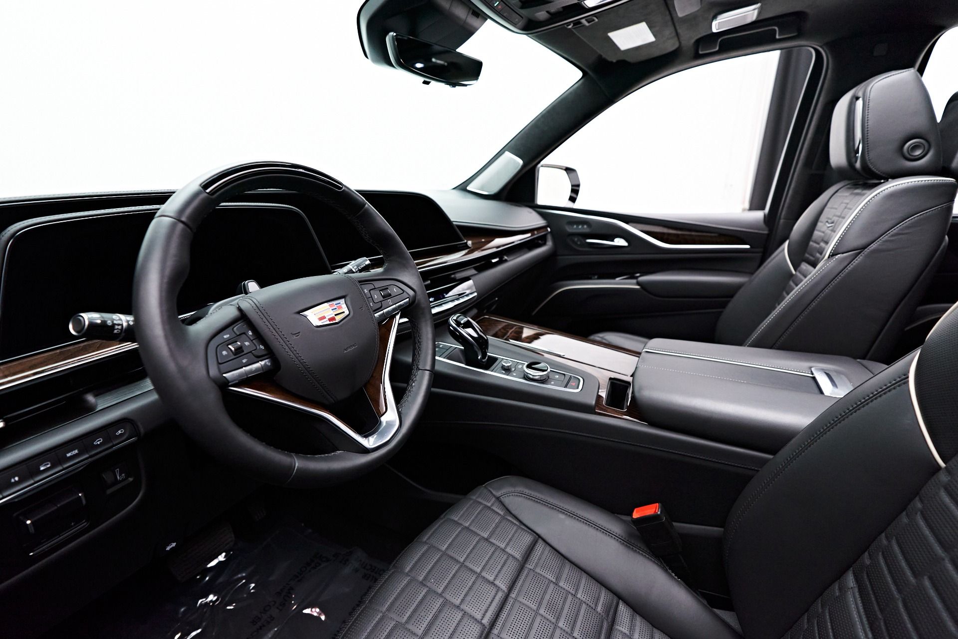 Luxury car interior with black leather seats, dashboard, and steering wheel viewed from the passenger side