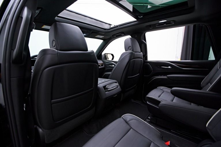 Luxury SUV interior with black leather seats and panoramic sunroof in a modern showroom