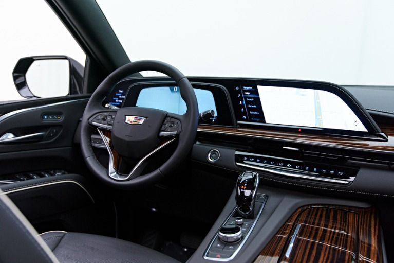 Luxury car interior with black leather seats, digital dashboard, and wood trim