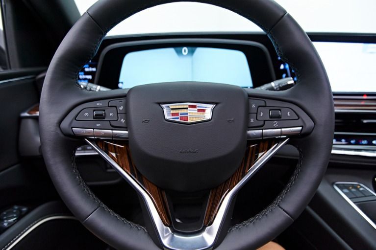Cadillac steering wheel and dashboard interior with digital instrument cluster and wood trim