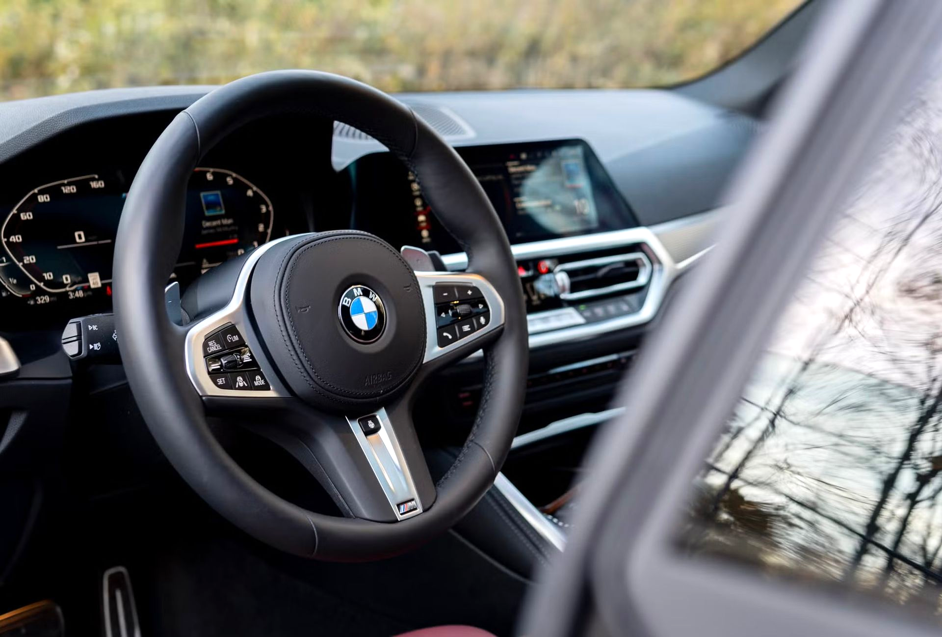 BMW steering wheel and dashboard viewed from the driver’s seat inside a car