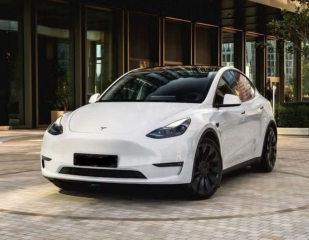 White Tesla Model Y parked outside a modern building