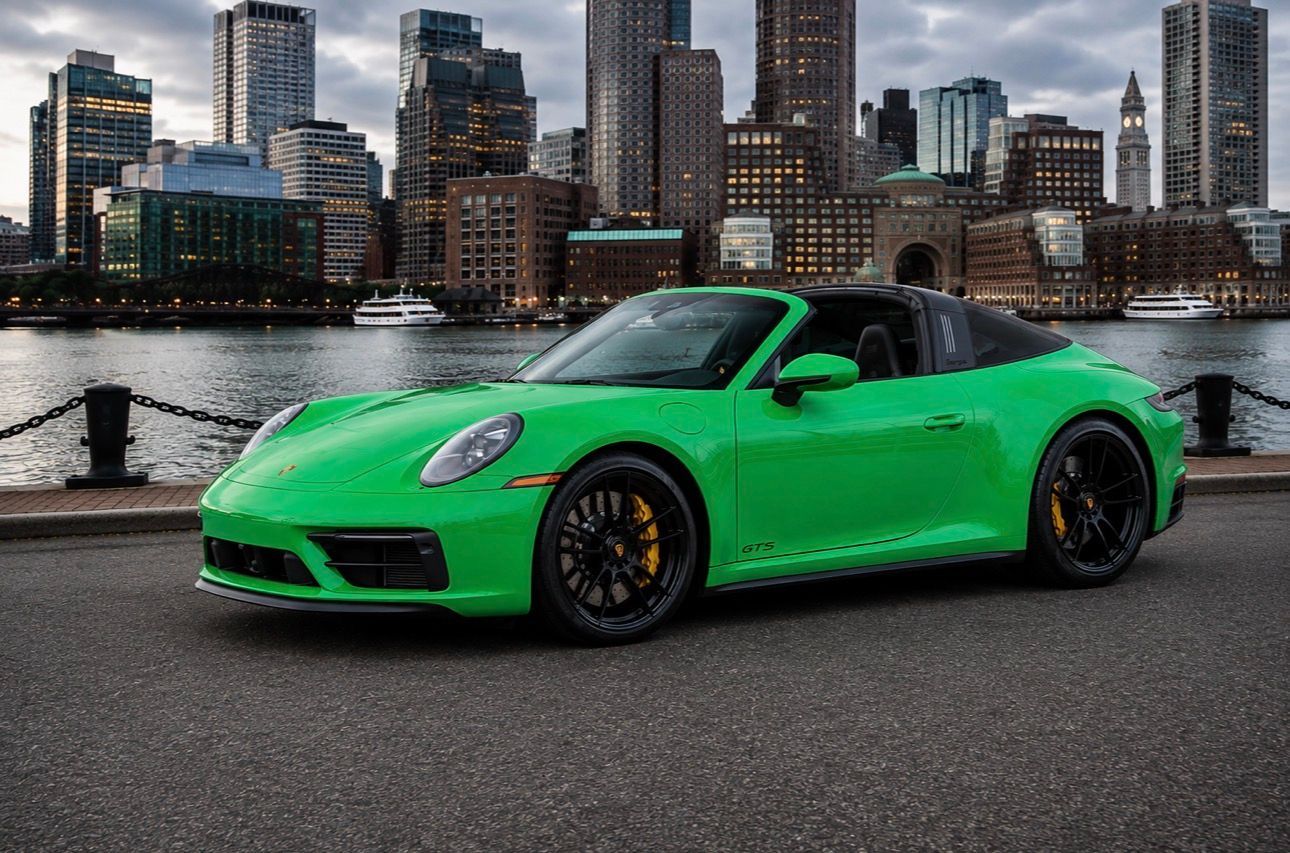 Porsche 911 Targa 4 GTS bright green sports car parked by a waterfront with a city skyline in the background