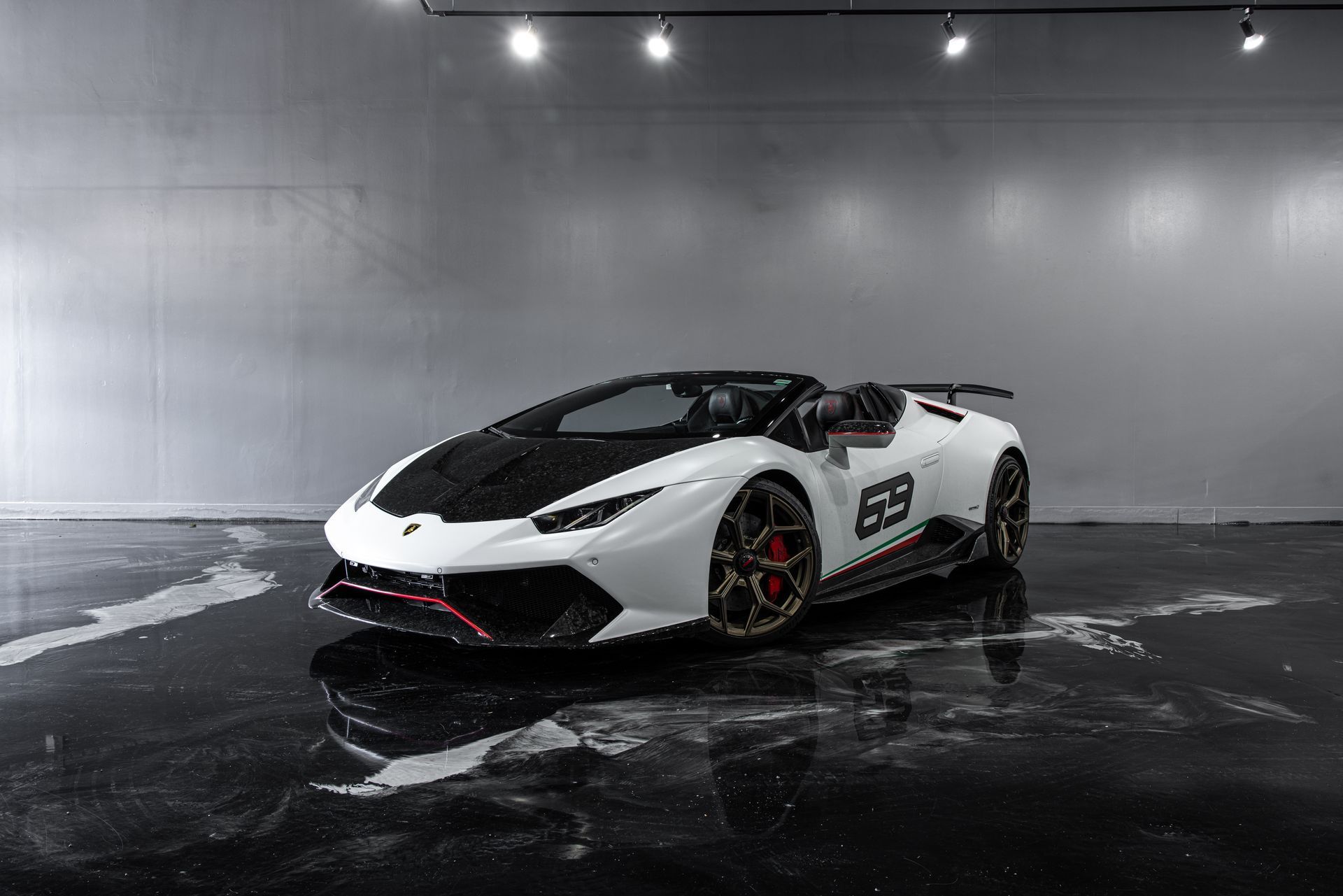 White Lamborghini Huracan Spyder with black accents, in a studio.