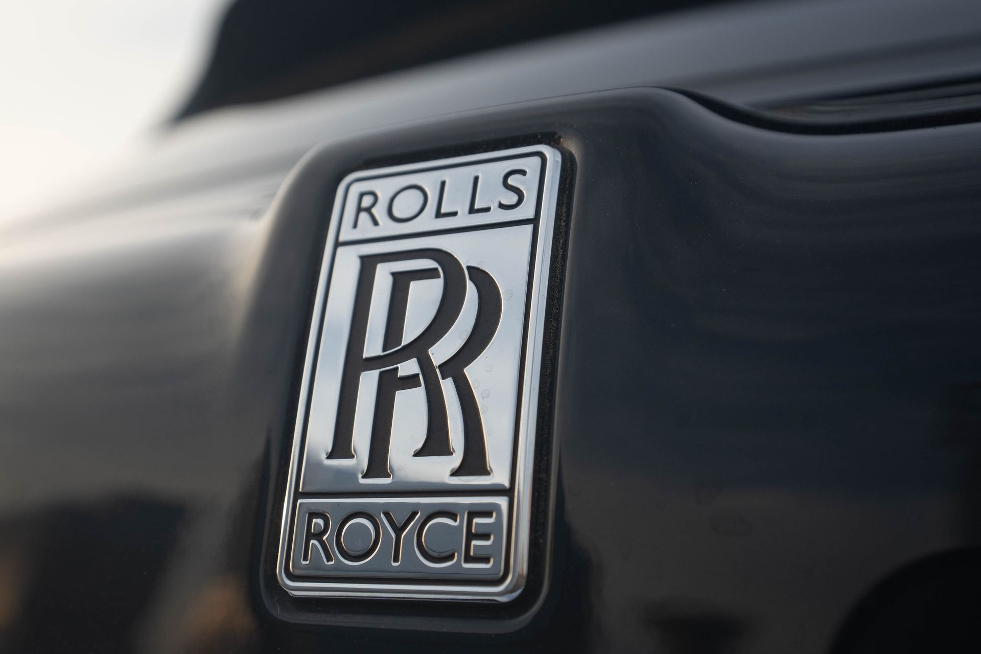 Rolls-Royce emblem on a black car hood close-up