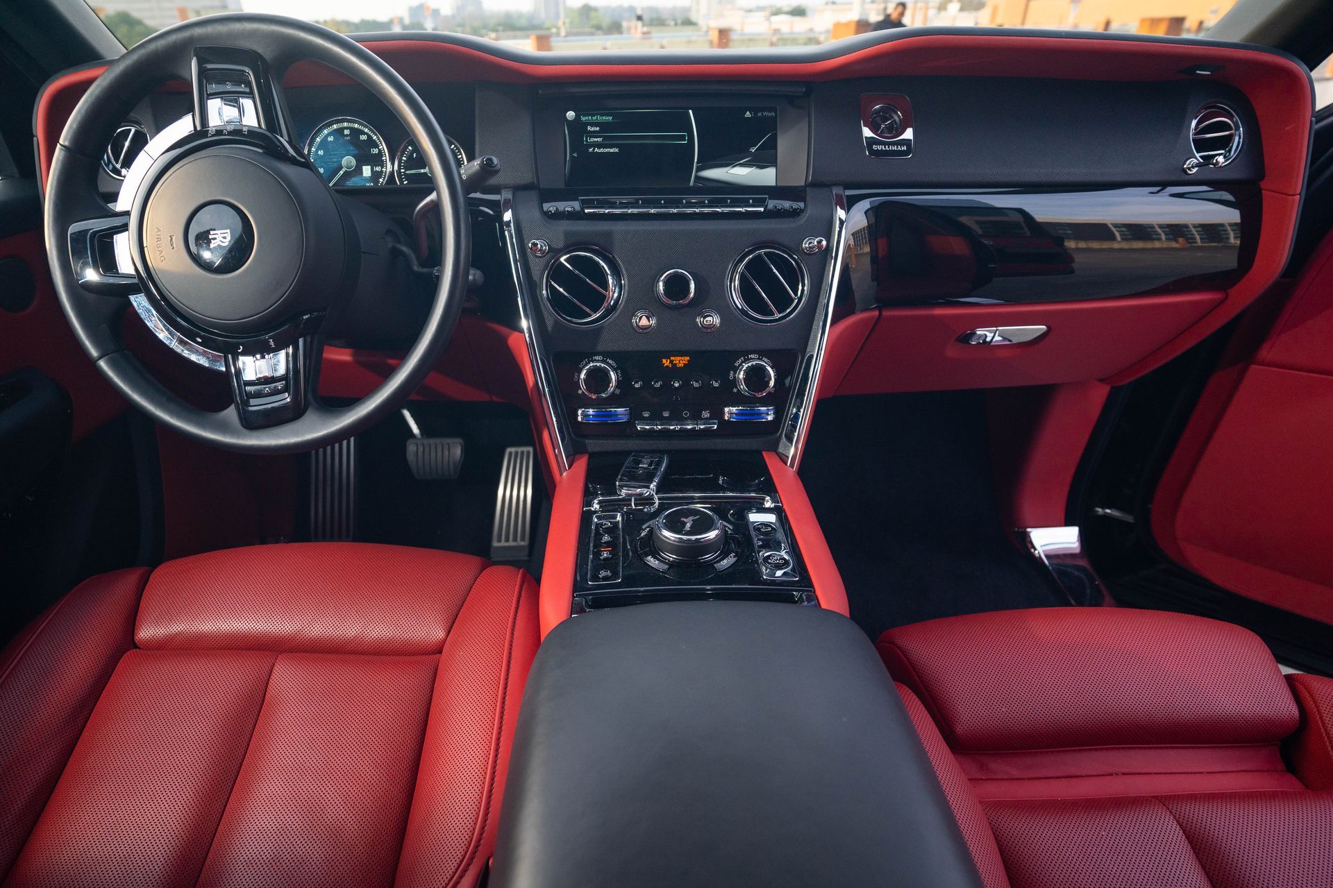 Red leather luxury car interior with steering wheel, dashboard, and center console