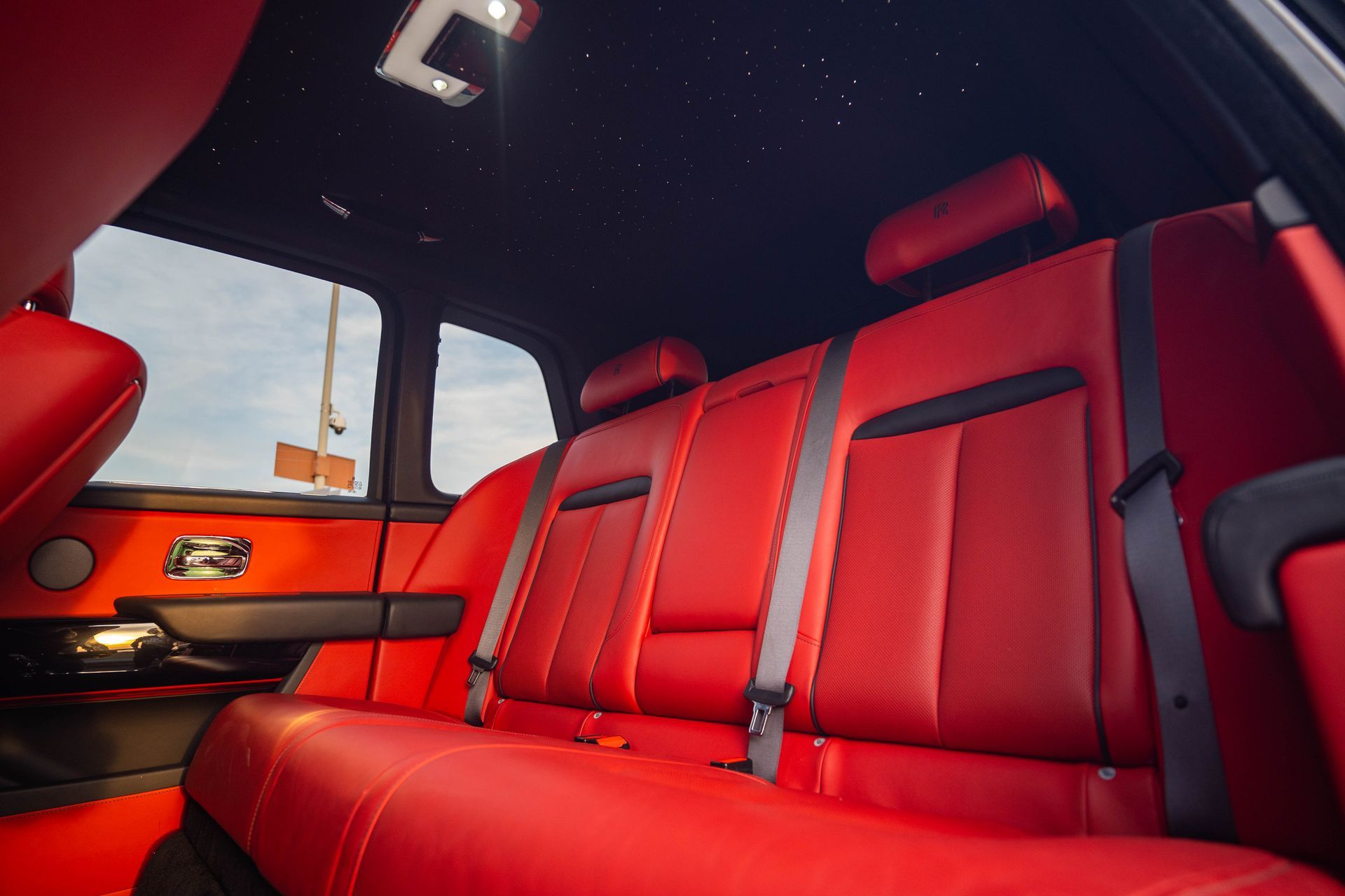 Red leather car back seat with black ceiling and orange door panel interior