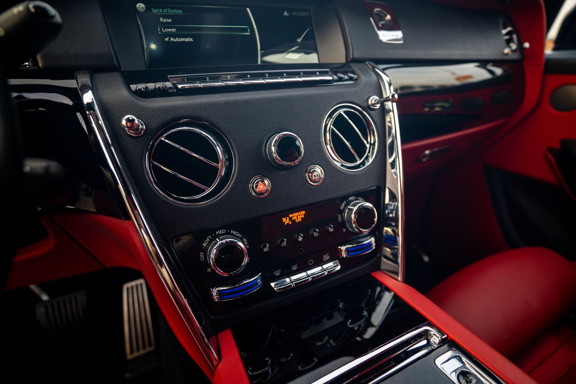 Red car interior with a glossy dashboard, central controls, and red-and-black seats