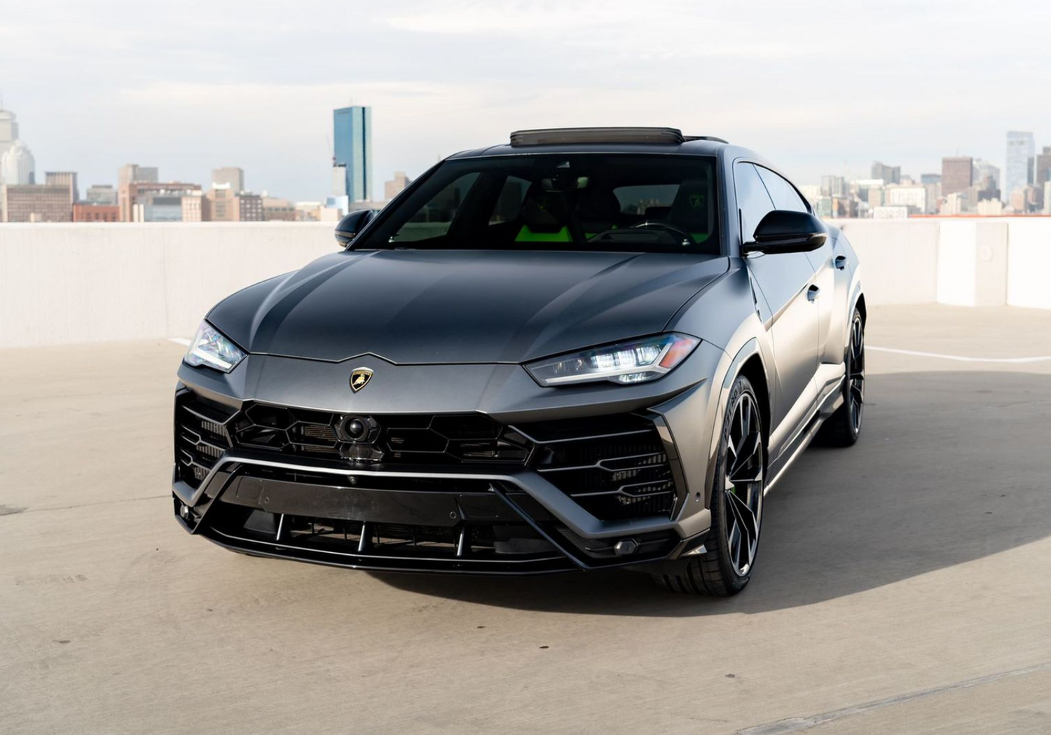 Black luxury SUV parked on a rooftop with a city skyline in the background