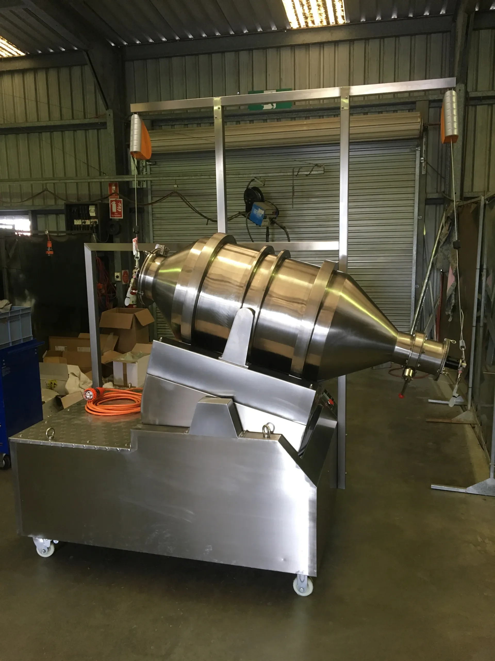 A large stainless steel machine is sitting in a warehouse. — Keystone Engineering Sheet Metal Industries in Noosaville, QLD