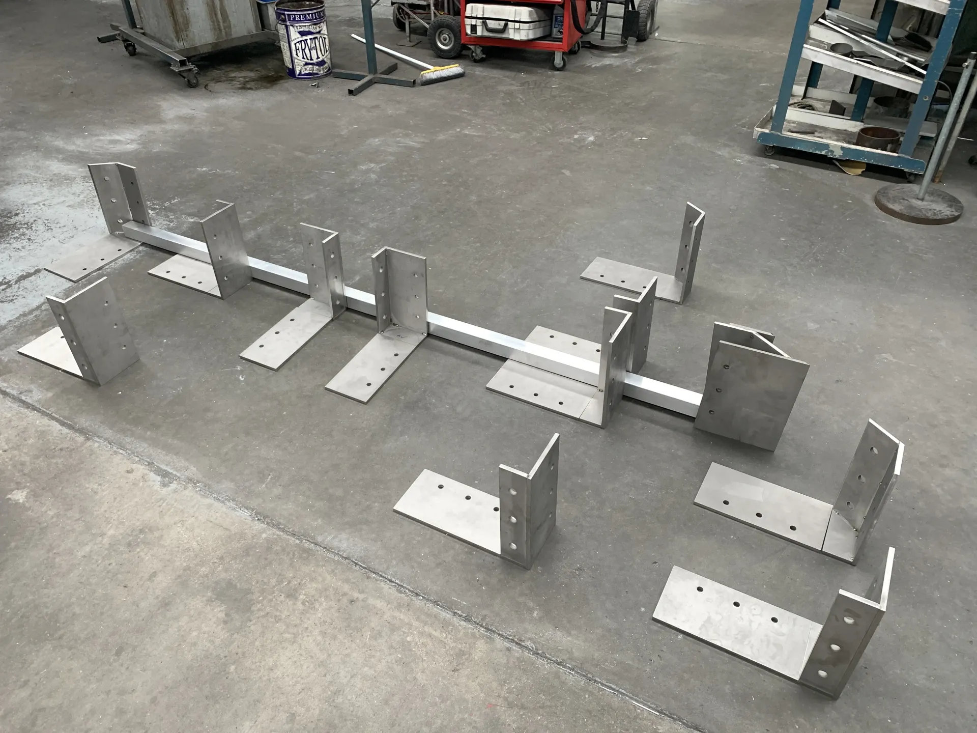A bunch of metal pieces are sitting on the ground. — Keystone Engineering Sheet Metal Industries in Noosaville, QLD