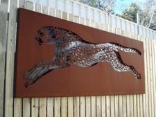 A painting of a cheetah is hanging on a wooden fence. — Keystone Engineering Sheet Metal Industries in Noosaville, QLD