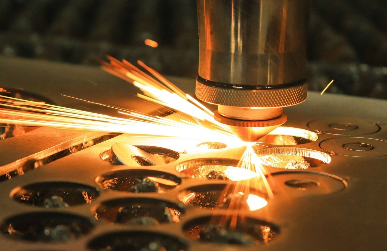 A machine is cutting a piece of metal with a lot of sparks coming out of it. — Keystone Engineering Sheet Metal Industries in Noosaville, QLD
