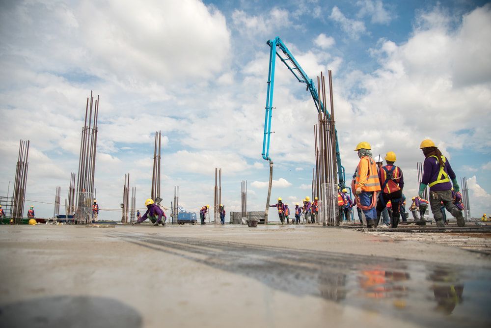 Men Construction Workers Are Working On A Building — Keystone Engineering Sheet Metal Industries in Noosaville, QLD