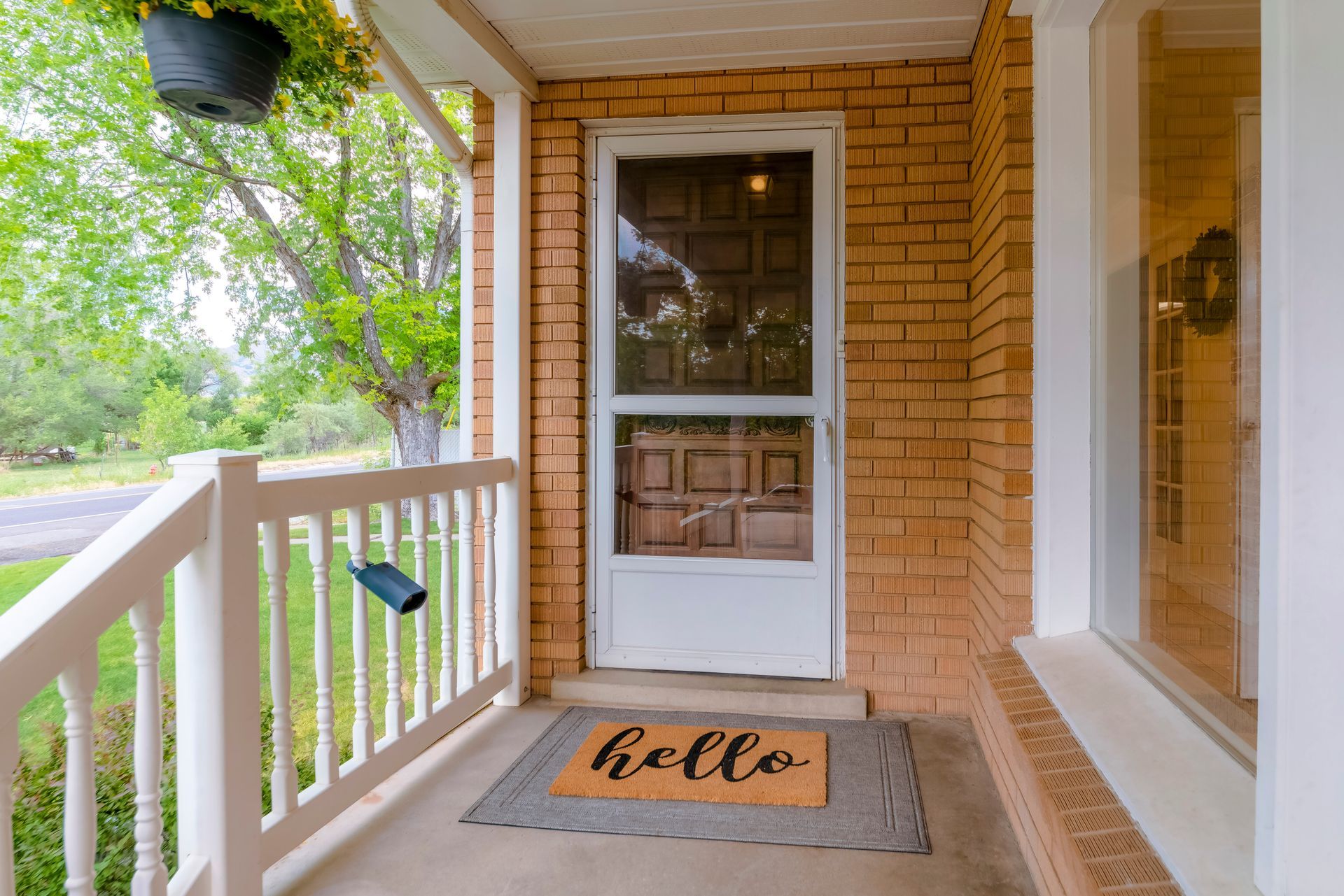 Front porch with brick, white trim, screen door, 