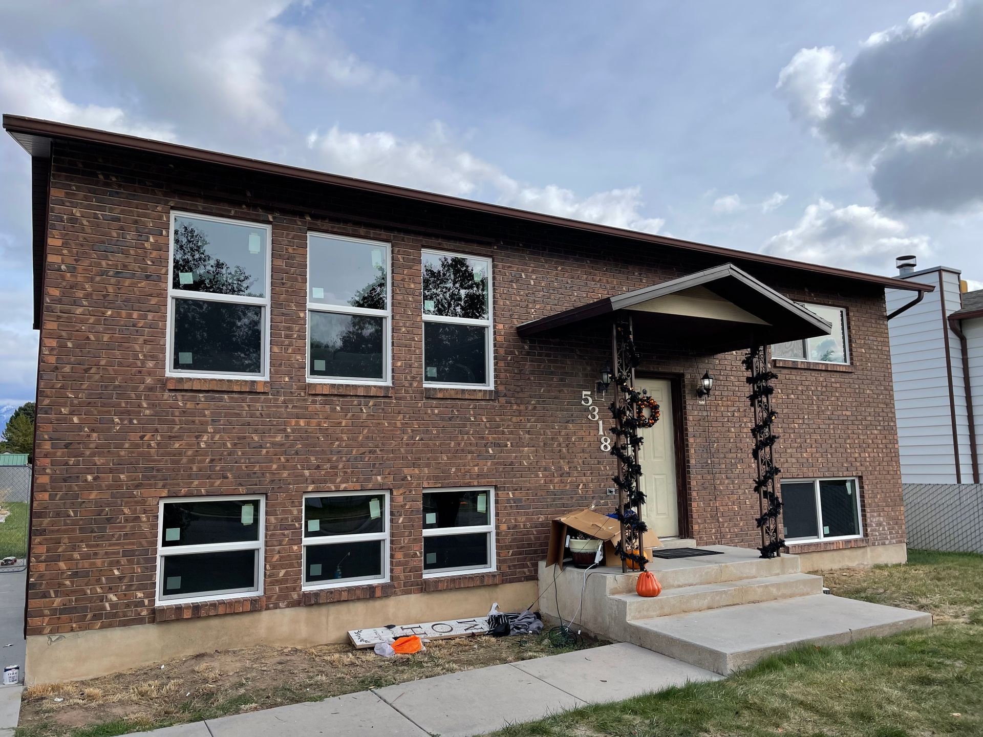 Brick house with new windows and covered entryway.