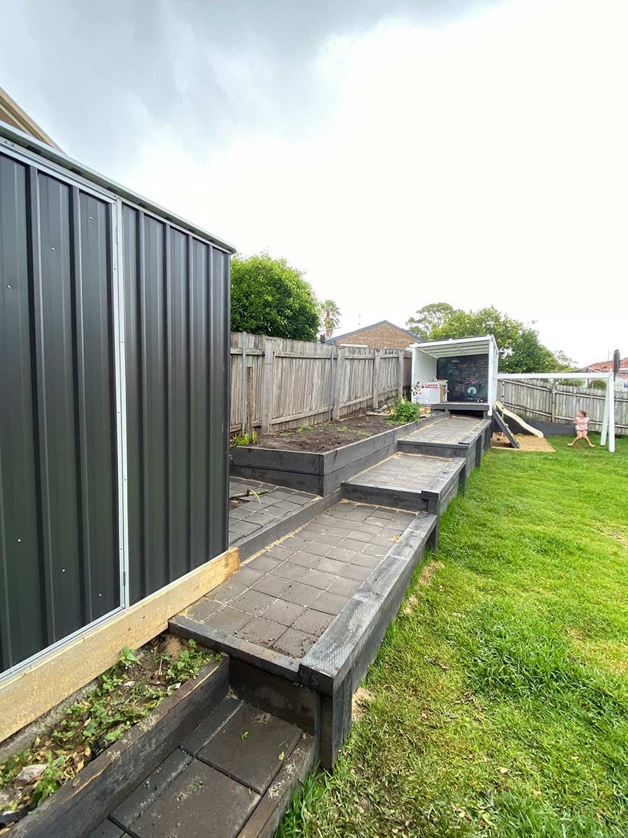 A Backyard With A Fence , Stairs , And A Shed — B Smart Building & Design In Figtree, NSW
