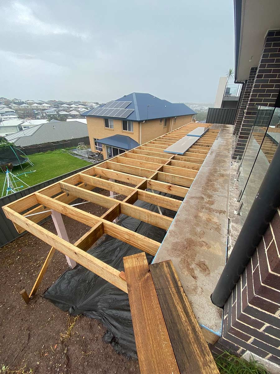A Wooden Deck Is Being Built On The Roof Of A House — B Smart Building & Design In Figtree, NSW