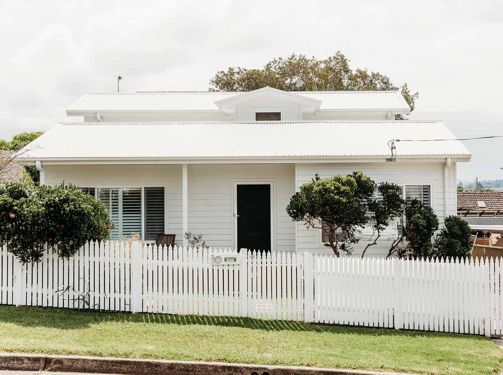 A White House With A White Picket Fence In Front Of It — B Smart Building & Design In Shellharbour, NSW