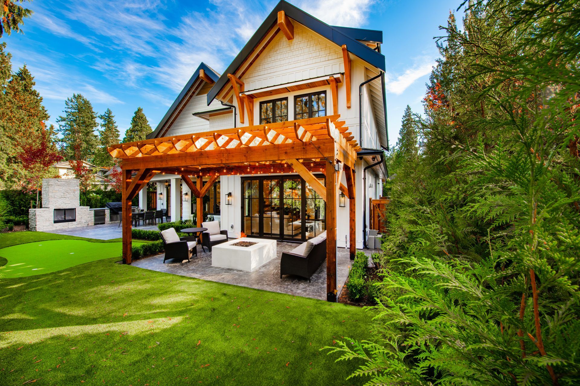 a house with a pergola and a fire pit in the backyard