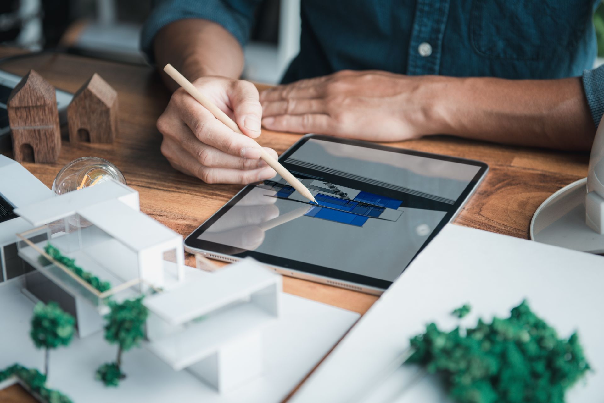 A man is drawing on a tablet with a pencil.