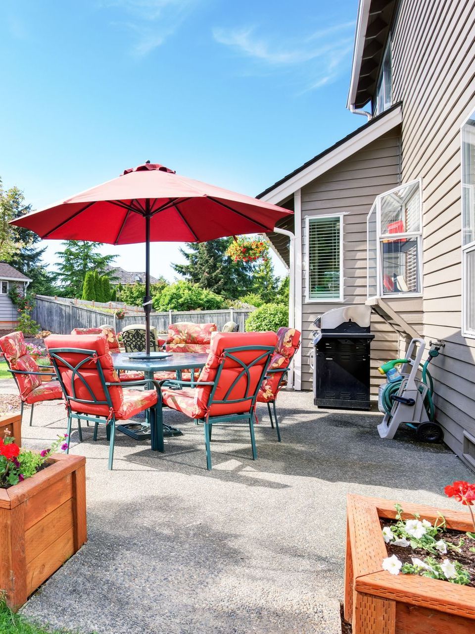 There is a patio with a table and chairs and an umbrella.