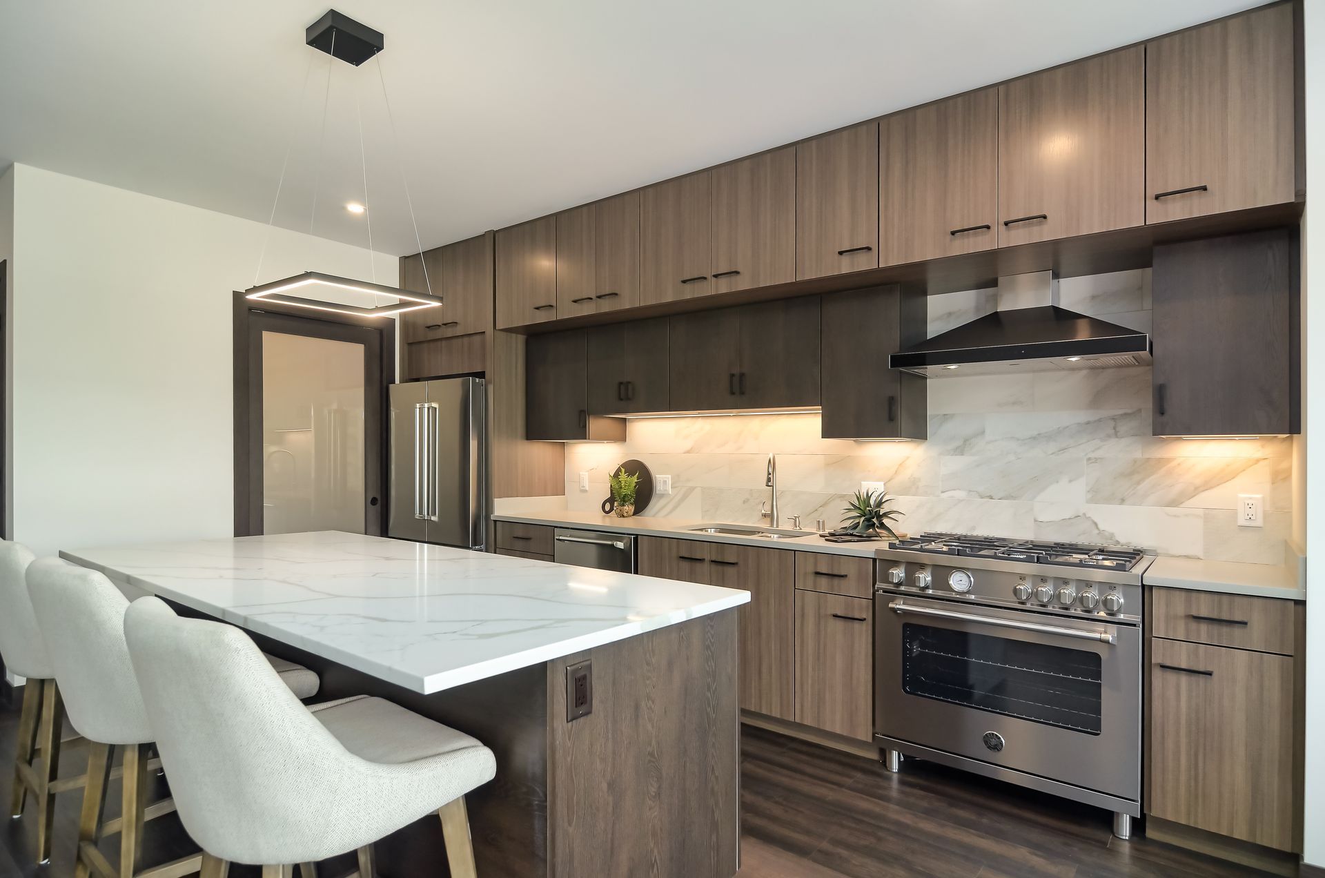 Modern kitchen with white island, stainless steel appliances, and wood cabinets at Ventana Apartments in Wayzata, MN.