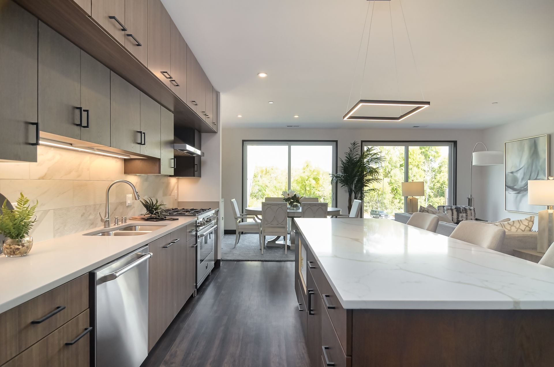 Modern kitchen with gray cabinets, marble countertops, stainless steel appliances, and a large island at Ventana Apartments in Wayzata, MN.
