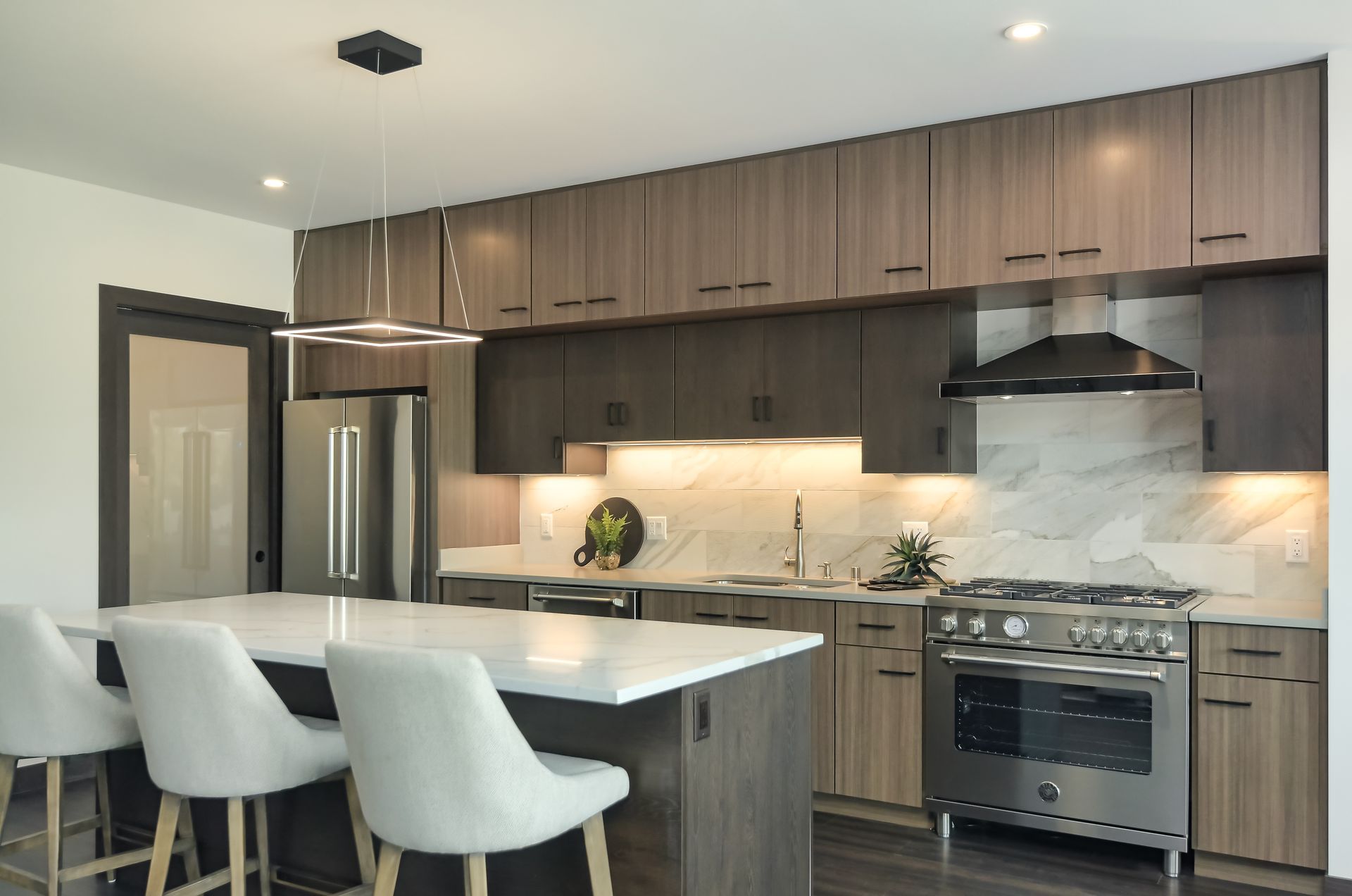 Modern kitchen with island, stainless steel appliances, and wood cabinetry at Ventana Apartments in Wayzata, MN.
