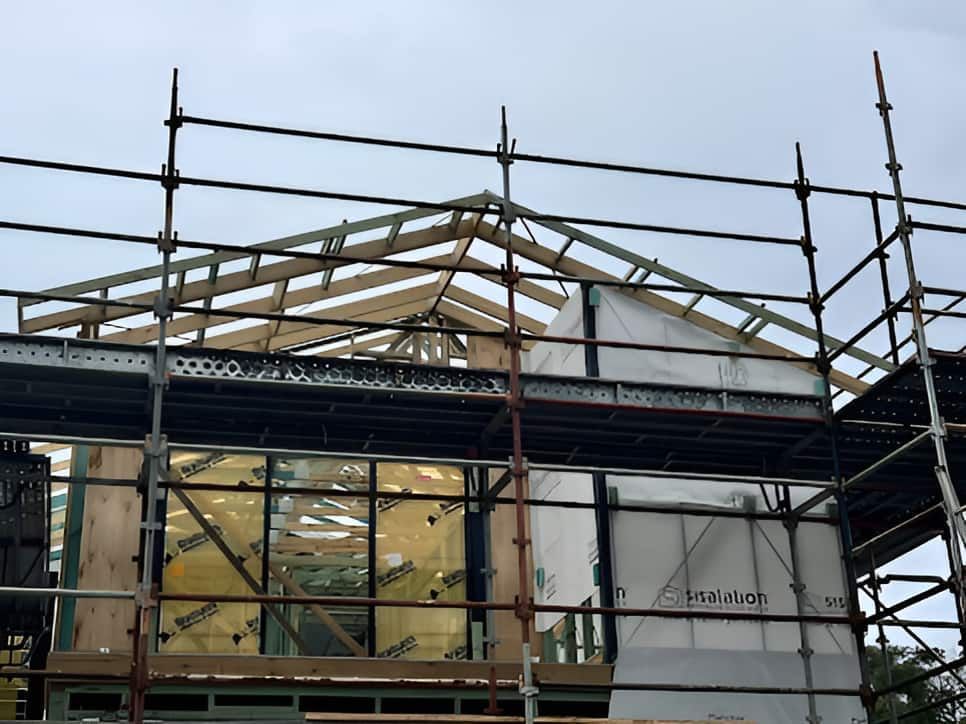 A House Is Being Built With Scaffolding Around It — Designer Building Pty Ltd In Belmont, NSW
