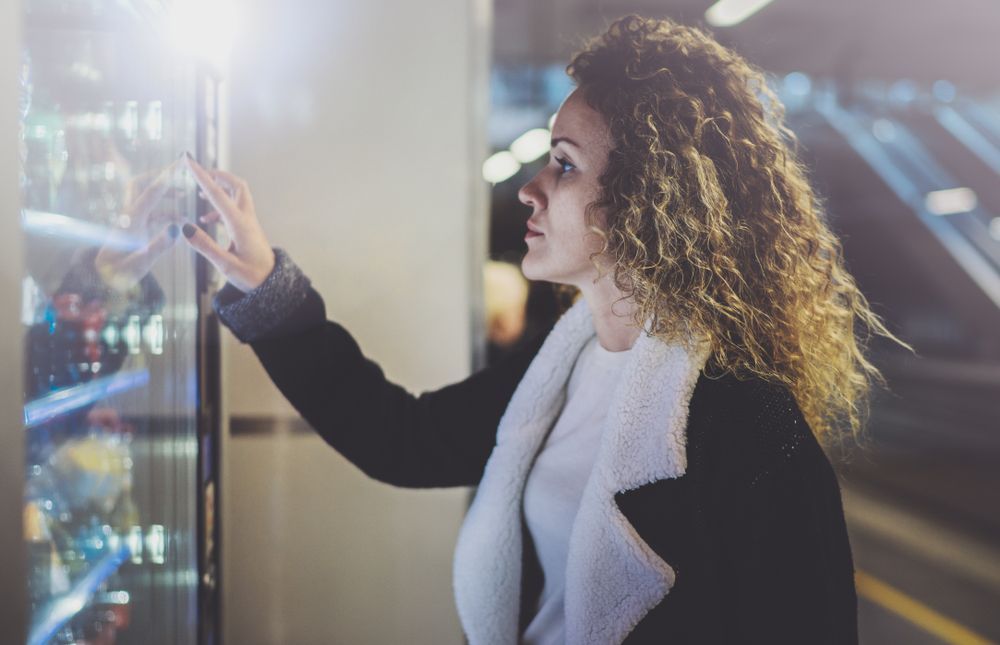 A Woman is Using a Vending Machine in a Parking Garage — Central Coast Storage Solutions in Yamba, NSW