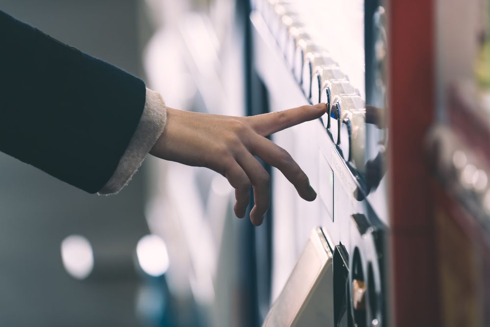 A Person is Pressing a Button on a Vending Machine — Central Coast Storage Solutions in Bellingen, NSW