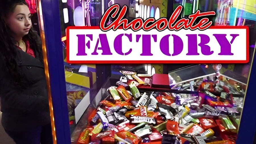 A Woman is Standing in Front of a Chocolate Factory Machine — Central Coast Storage Solutions in Kempsey, NSW