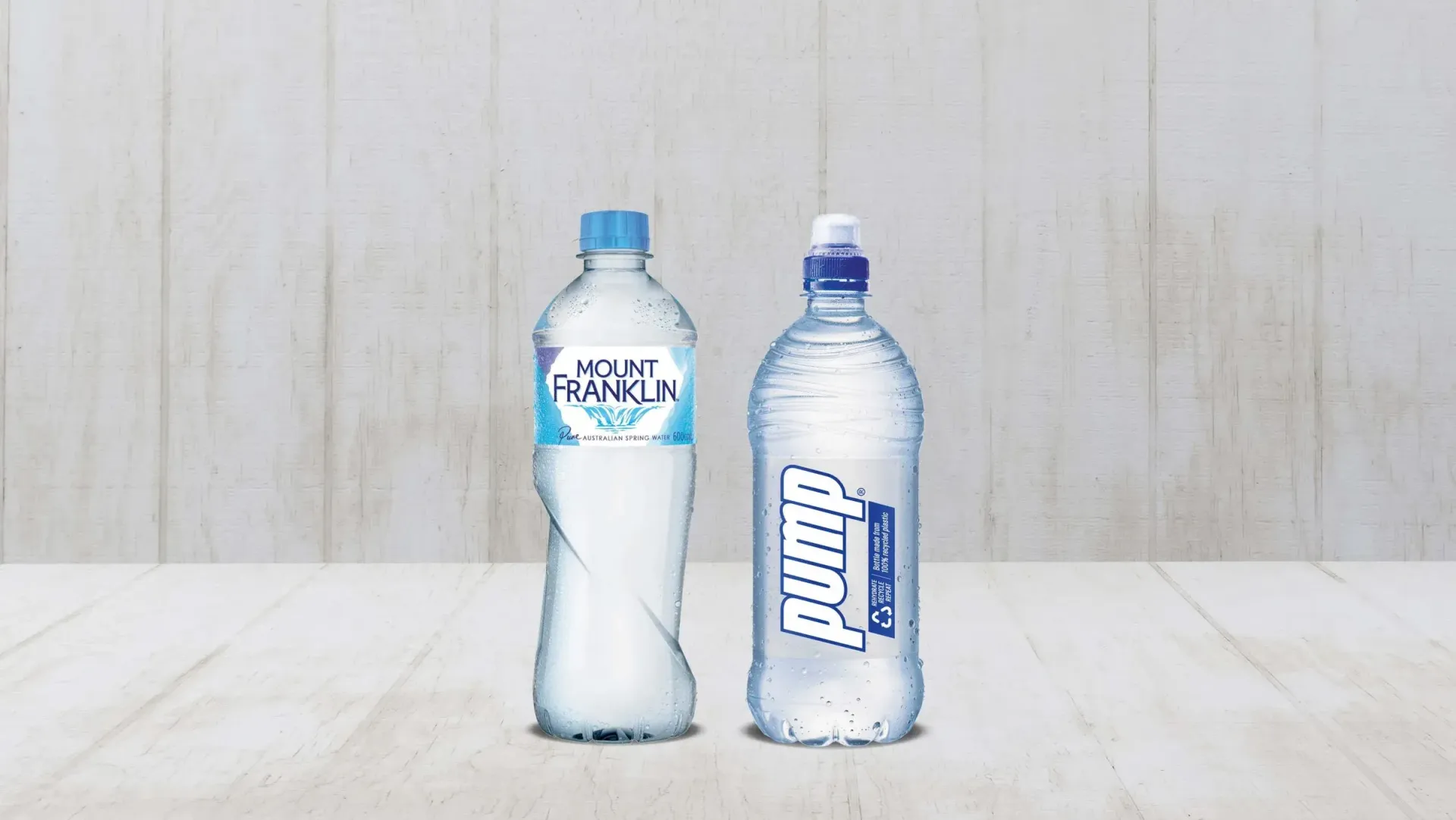 Two Bottles of Water Are Sitting on a Wooden Table — Central Coast Storage Solutions in Toormina, NSW