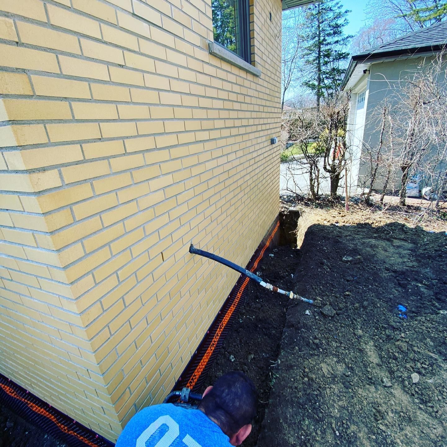 A man is working on the side of a brick building.