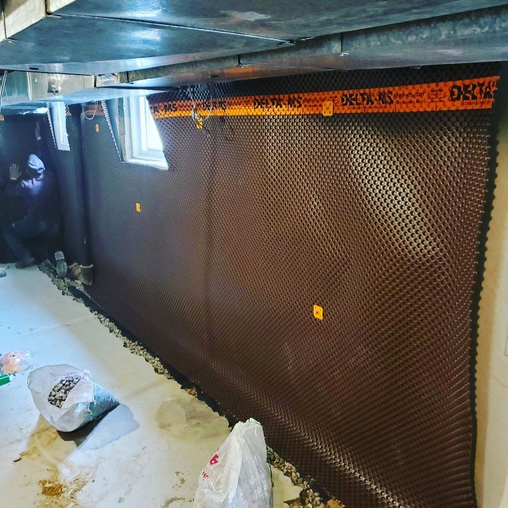 A man is working on a wall in a basement.