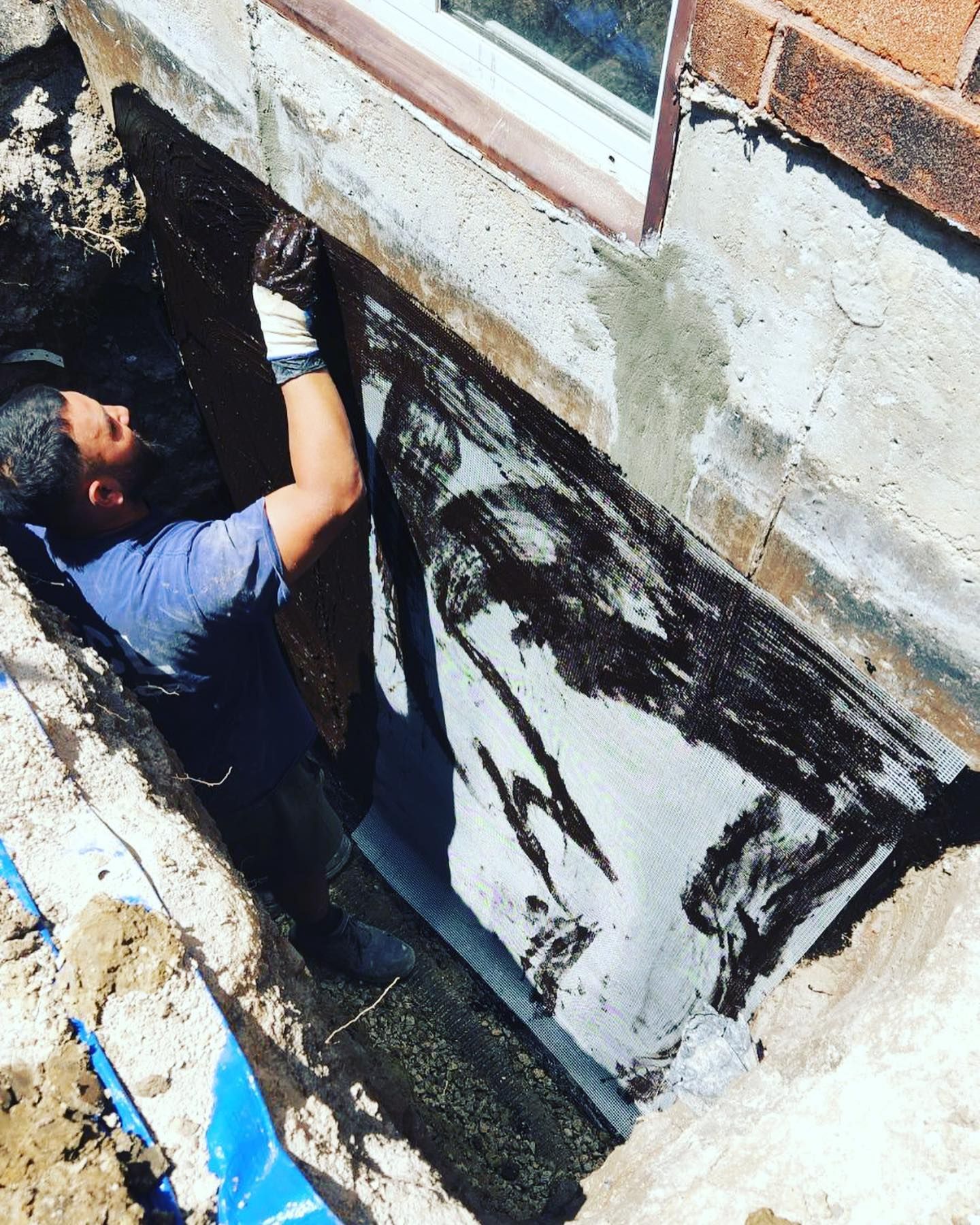 A man is working on the side of a building.