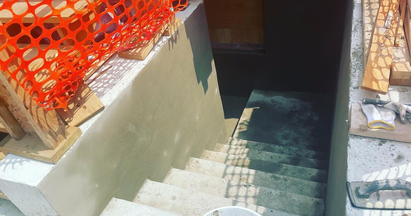 A set of stairs leading up to a basement under construction.