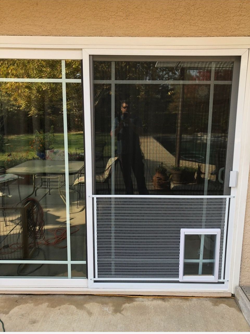 A sliding glass door with a dog door on it
