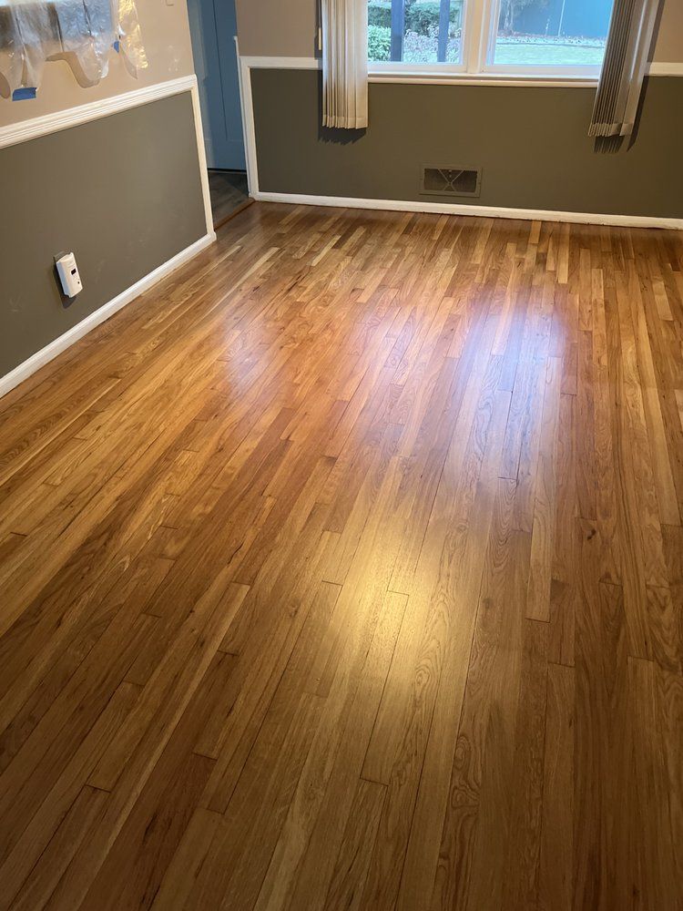 A living room with hardwood floors and a window.
