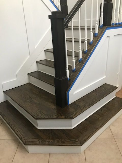 A man is kneeling down to install a wooden floor.