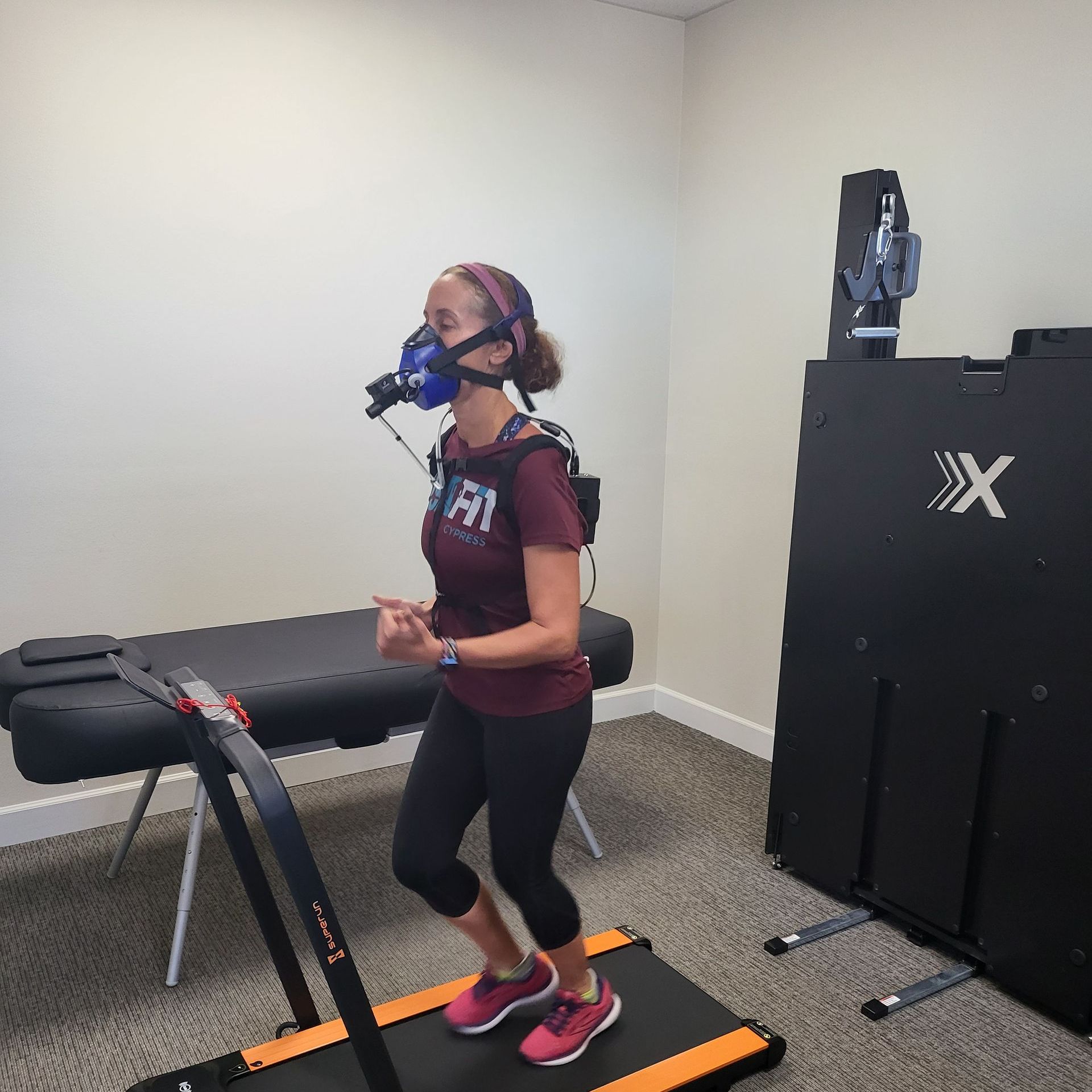 A woman running on a treadmill while using a metabolic breath analyzer for VO2 Max Testing, highlighting the role of this assessment in providing a Precise Fitness Assessment. It delivers accurate insights into cardiovascular fitness, enabling tailored exercise plans for more effective workouts based on individual fitness levels and goals.
